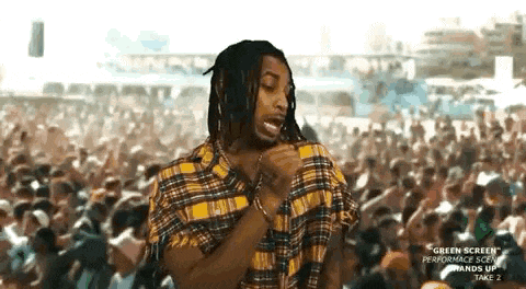 a man in a plaid shirt is standing in front of a crowd of people .