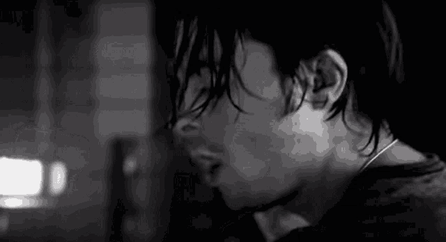 a close up of a man 's face in a black and white photo with wet hair .
