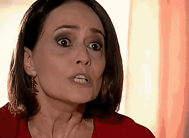 a woman in a red shirt is making a face