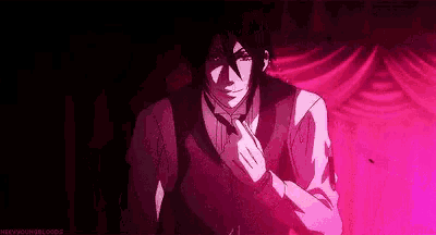 a man in a suit and tie is standing in front of a pink curtain ..