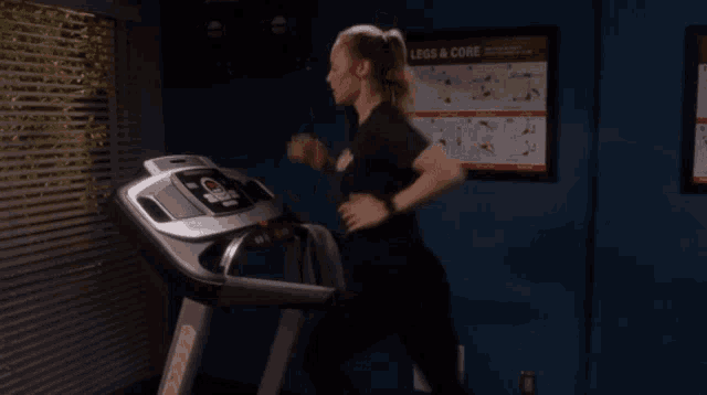 a woman is running on a treadmill in front of a poster that says ' exercise & core '
