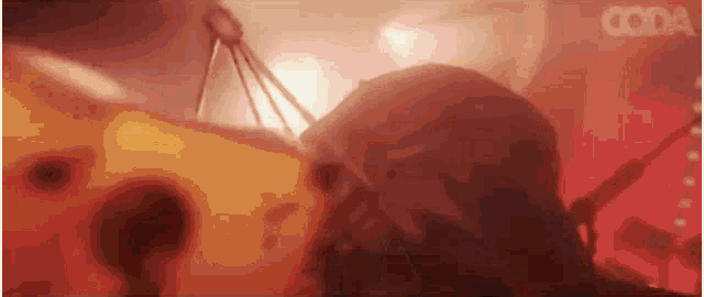 a close up of a person 's face in a dark room with a red background .