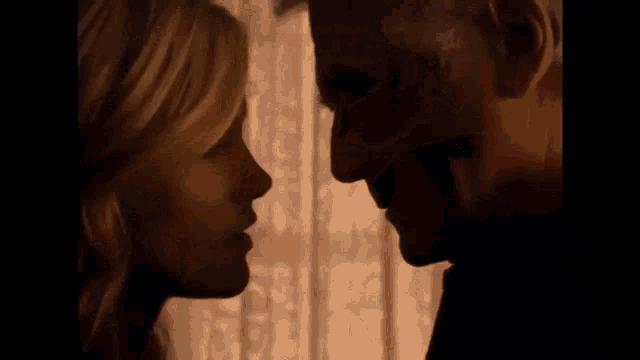 a close up of a man and woman kissing