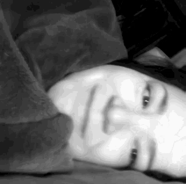 a woman is laying under a blanket on a bed .