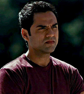a man in a maroon shirt is making a face