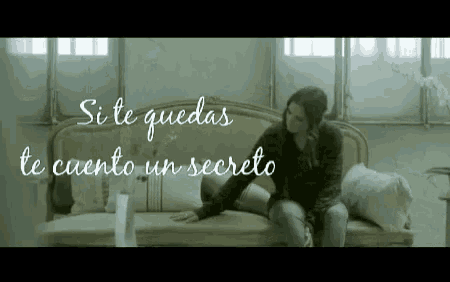 a woman is sitting on a couch with the words " si te quedas te cuento un secreto " written above her