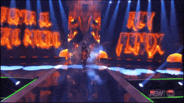 a man walking on a stage with a sign that says rey fenix on it