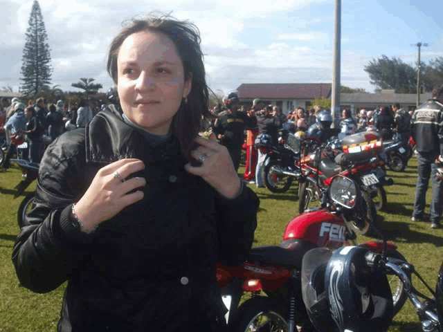 a woman stands in front of a row of motorcycles including one that says fel