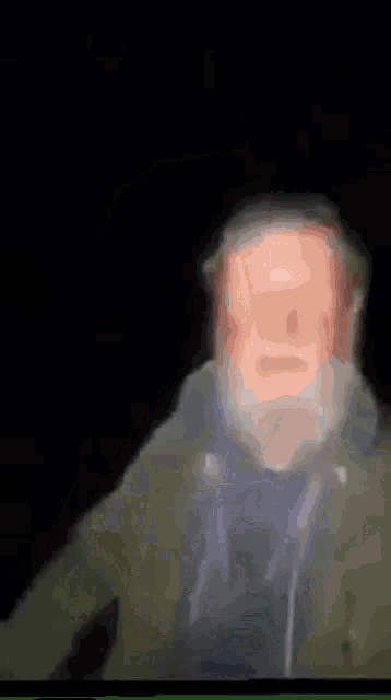 a blurry picture of a man with a beard and a hat .