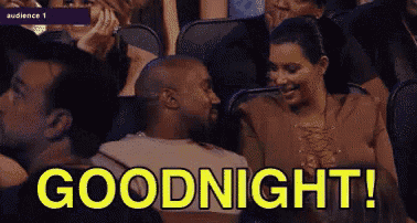 a man and a woman are sitting in a stadium with the words `` goodnight '' written in yellow .