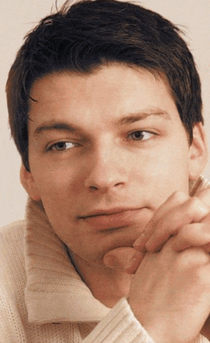 a close up of a man with his hand on his chin
