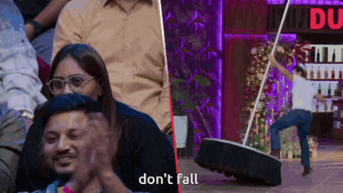 a man is doing a trick on a tire and a woman is clapping in the audience
