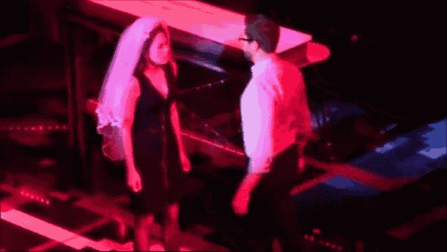 a man and a woman are dancing on a stage in a dark room .