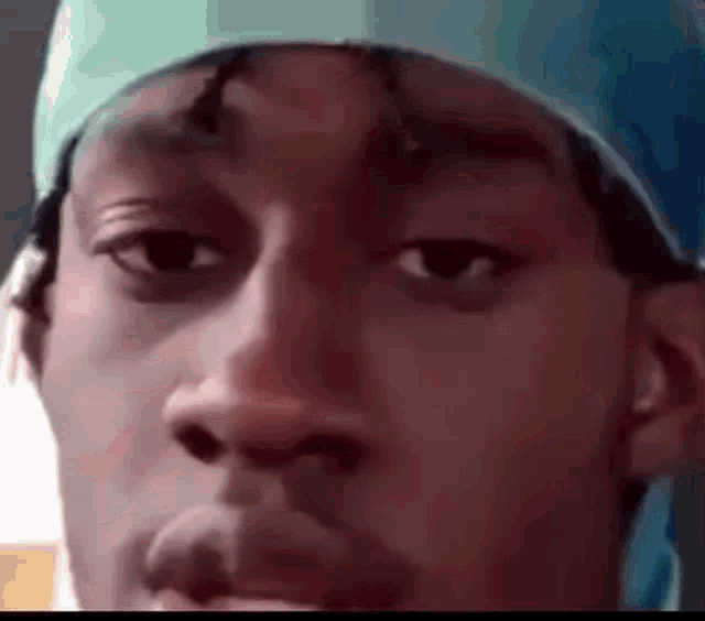 a close up of a man 's face wearing a bandana and a hat .