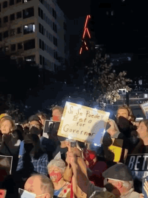 a crowd of people holding up signs one of which says si se puede beto for governor