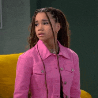 a girl with braids is wearing a pink jacket .