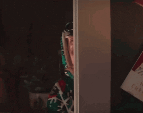 a man with a mustache and goggles is peeking through a door