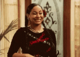 a woman with a flower in her hair is smiling in front of a glass door .