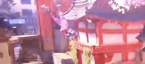 a person is flying through the air in front of a red building in a room .