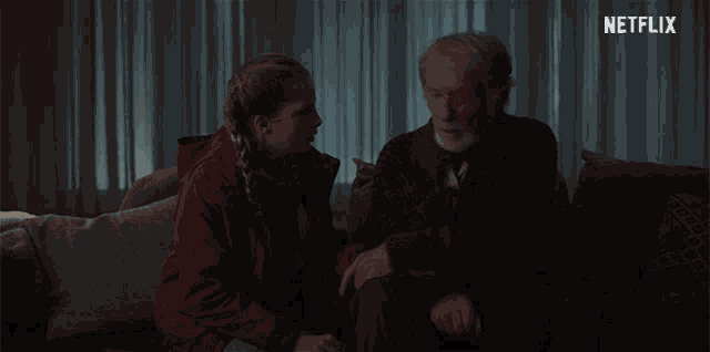 a man and a woman are sitting on a couch with a netflix logo in the background