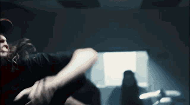 a blurry picture of a person holding another person 's arm in a dark room