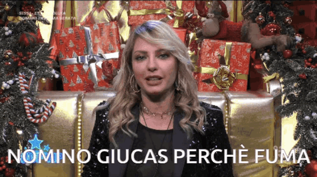 a woman is sitting in front of a christmas tree with the words nomino giucas perche fuma