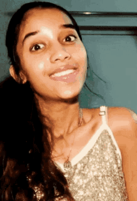 a close up of a woman 's face with a ponytail and a smile on her face