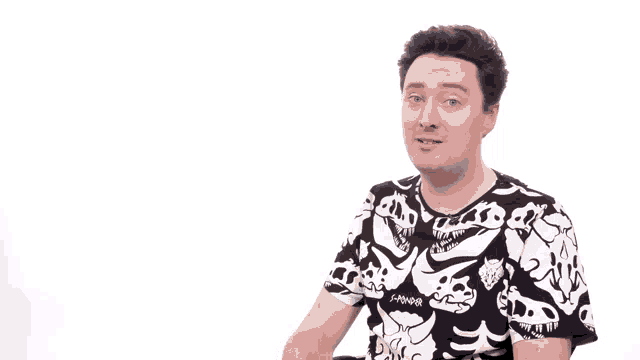 a man wearing a black and white t-shirt with skulls on it gives a thumbs up