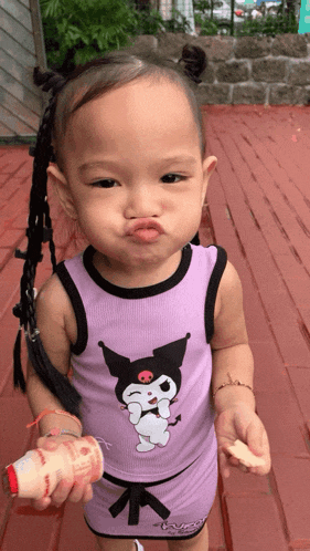 a little girl wearing a purple outfit with a cartoon character on it