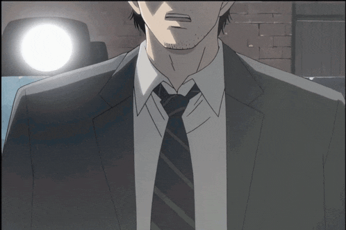 a man in a suit and tie stands in front of a brick wall