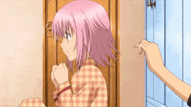 a person in plaid pajamas is standing in a doorway with their feet up