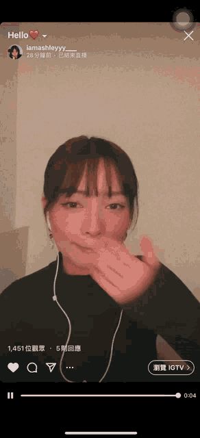 a woman wearing ear buds and a black shirt with the word hello on the top