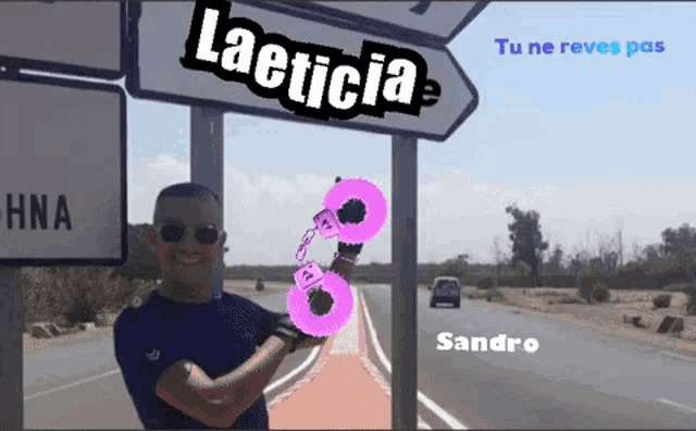 a man is holding a pair of pink handcuffs in front of a sign that says laeticia