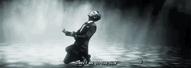 a man in a suit is kneeling down with the words direct me to the sun written above him
