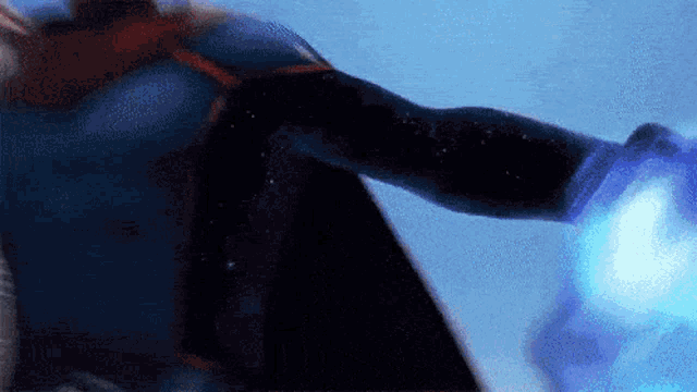 a person in a superhero costume is holding a blue object