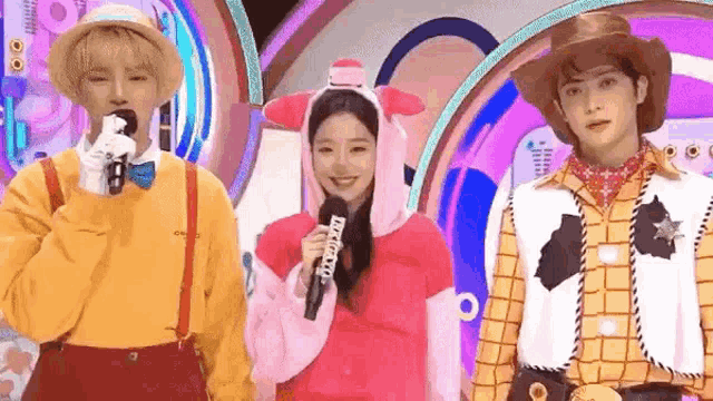 a girl in a winnie the pooh costume is standing next to a man in a woody costume .