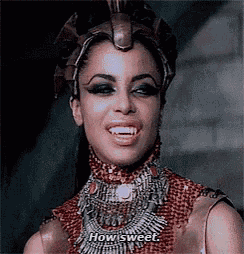 a woman with vampire teeth is wearing a crown and necklace and says `` how sweet '' .