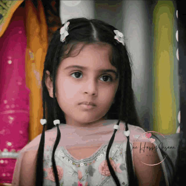 a little girl is looking at the camera with a watermark that says " the happy human "