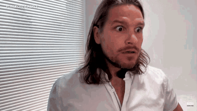 a man with long hair and a beard looks surprised