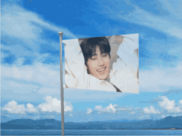 a flag with a picture of a man on it is flying in the wind