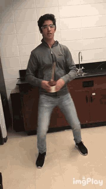a man in a columbia jacket is standing in a kitchen