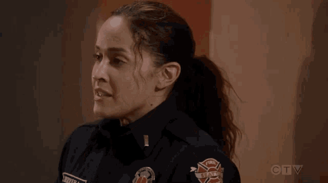 a woman in a firefighter uniform is looking down