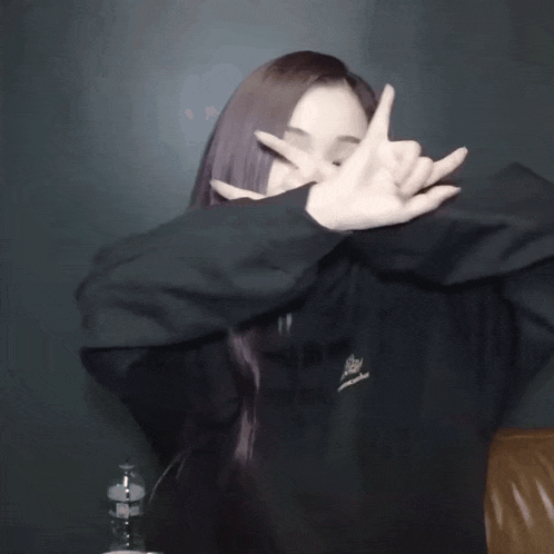 a woman with purple hair is wearing a black sweatshirt with the word crown on it