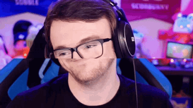 a man wearing glasses and headphones is making a face