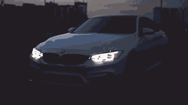 a white bmw car is parked in the dark