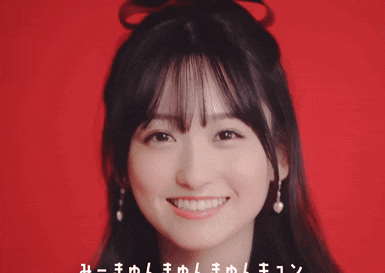 a girl with a bow in her hair is smiling in front of a red background with chinese writing