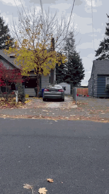 a silver car is parked in front of a house