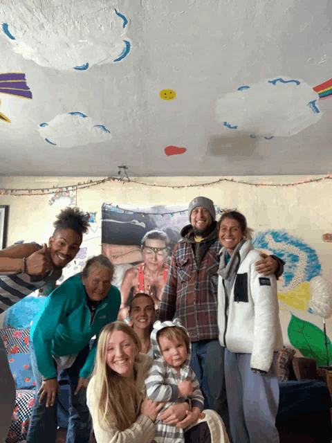 a group of people are posing for a picture in front of a painting on the ceiling