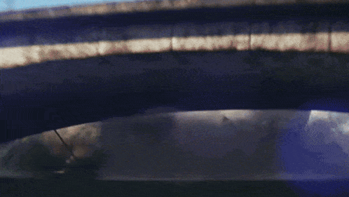 a blurred image of a bridge with a few cars on it