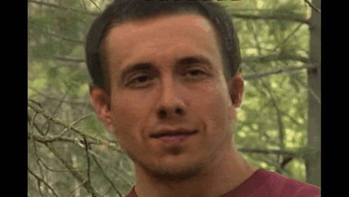 a close up of a man 's face with trees in the background